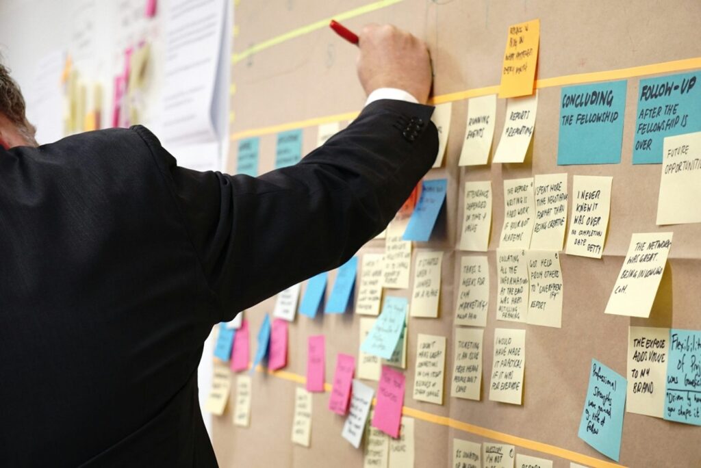 person sticking sticky notes to a board