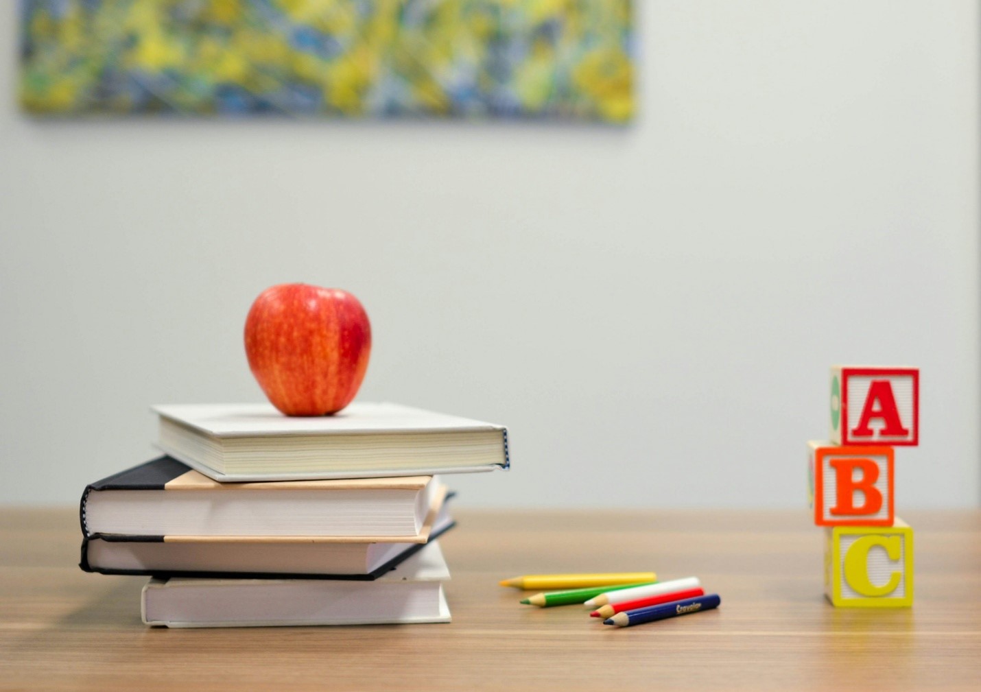 a red apple on a pile of books